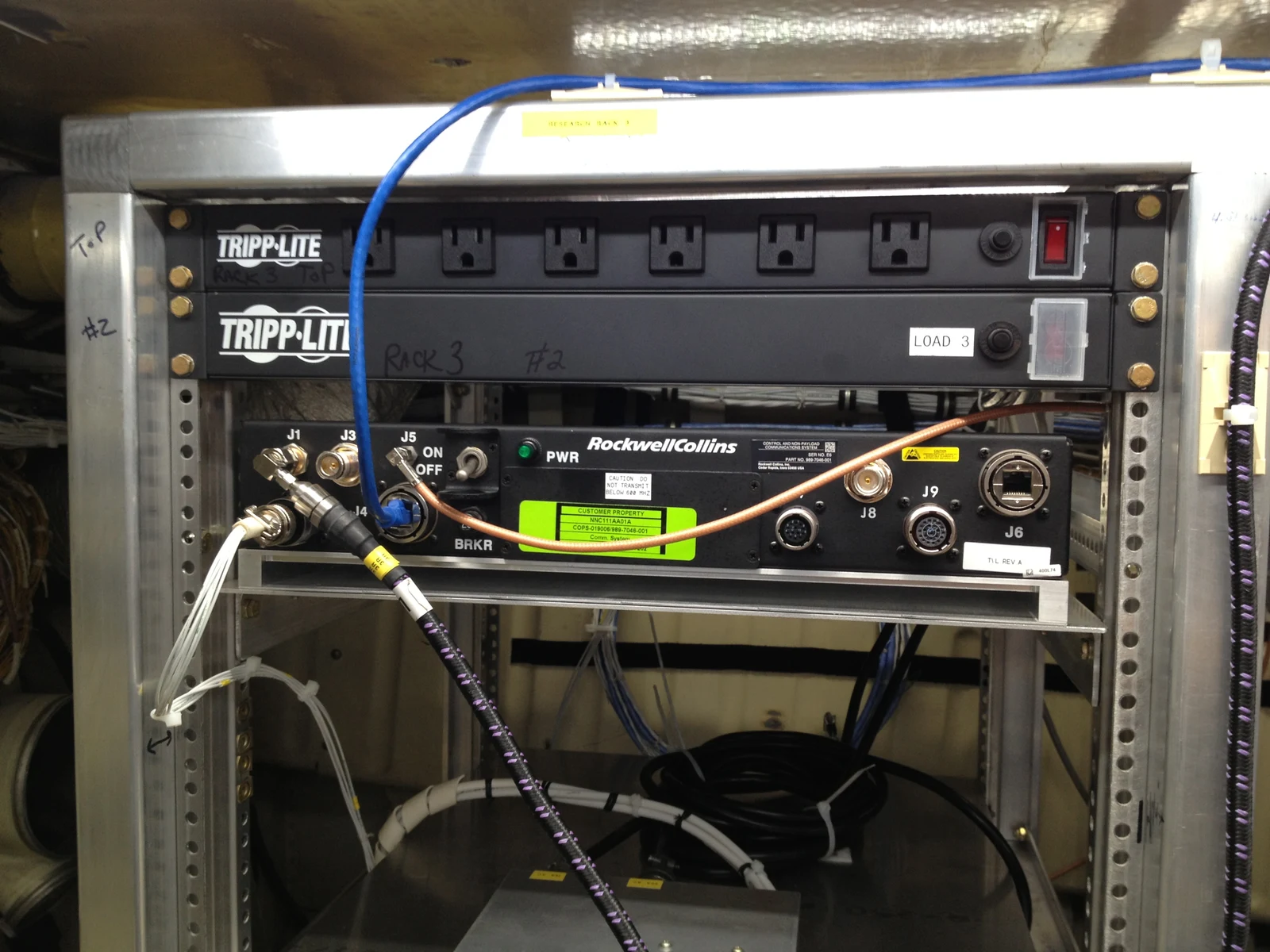 Prototype command-and-control radio and connected cables in a test rack aboard a NASA S-3 research aircraft.